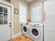 Bright laundry room with new washer and dryer set, white cabinetry for storage, and tile flooring at 606 Howell Ave, Brooksville, FL 34601
