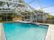 A screened in pool includes an integrated spa, and patio waterfall at 606 Howell Ave, Brooksville, FL 34601