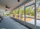 Large screened-in porch with ceiling fans offers views of the well-manicured lawn and mature trees at 606 Howell Ave, Brooksville, FL 34601