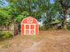 Red storage shed provides backyard storage at 606 Howell Ave, Brooksville, FL 34601
