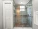 Shower with stone flooring, a glass enclosure, and tiled walls at 606 Howell Ave, Brooksville, FL 34601