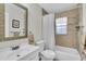 Well-lit bathroom with a shower-tub combo, decorative mirror, and modern fixtures at 6219 Wilds Dr # 11A, New Port Richey, FL 34653