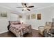 Cozy bedroom featuring hardwood floors, a ceiling fan, and a comfortable reading chair at 6219 Wilds Dr # 11A, New Port Richey, FL 34653