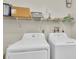Functional laundry room featuring a washer, dryer, and shelving for storage at 6219 Wilds Dr # 11A, New Port Richey, FL 34653
