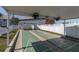 Covered shuffleboard courts with painted details, seating, and surrounded by a white picket fence at 6219 Wilds Dr # 11A, New Port Richey, FL 34653
