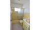 Well-lit bathroom features a tub with glass doors, a tile backsplash, a toilet, and a sink with a vanity at 6327 Skyline Ct, Spring Hill, FL 34606