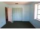 Cozy bedroom with blue walls, a double-door closet, and a window overlooking the property's exterior at 6327 Skyline Ct, Spring Hill, FL 34606
