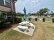 Outdoor patio area with picnic table, charcoal grill, and green landscaping at 6338 Spring Flower Dr # 15, New Port Richey, FL 34653
