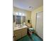 Bathroom with single sink vanity, toilet, decorative mirror, and updated lighting at 6338 Spring Flower Dr # 15, New Port Richey, FL 34653