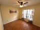 Cozy bedroom features wood floors, ceiling fan, and large window providing ample natural light at 6338 Spring Flower Dr # 15, New Port Richey, FL 34653
