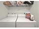 Functional laundry room features a white washer and dryer with wire shelving for storage at 7644 St Andrews Blvd # 0, Weeki Wachee, FL 34613