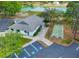 Aerial view featuring a community clubhouse with nearby parking, shuffleboard, and lush green space at 7662 St Andrews Blvd, Weeki Wachee, FL 34613