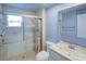 Bathroom with glass-enclosed shower, a large single sink vanity, and blue accents at 7662 St Andrews Blvd, Weeki Wachee, FL 34613