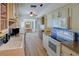 Bright kitchen featuring light cabinets, stone countertops, tile backsplash, hardwood floors, and stainless appliances at 7662 St Andrews Blvd, Weeki Wachee, FL 34613