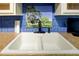 Kitchen sink featuring a double basin with a stylish faucet, tile backsplash and solid countertop at 7662 St Andrews Blvd, Weeki Wachee, FL 34613