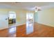 Bright living room featuring sleek hardwood floors, a ceiling fan, and access to the bar and dining room at 7662 St Andrews Blvd, Weeki Wachee, FL 34613