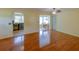 Bright living room featuring sleek hardwood floors, a ceiling fan, and access to the bar and dining room at 7662 St Andrews Blvd, Weeki Wachee, FL 34613