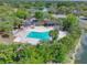 Aerial view of community pool surrounded by lush trees and landscaping, creating a private oasis at 7662 St Andrews Blvd, Weeki Wachee, FL 34613