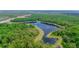 Beautiful Florida lake nestled among lush green trees and foliage at 7827 Starfire Way, New Port Richey, FL 34654