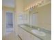 Bright bathroom featuring double sinks and a large mirror at 7827 Starfire Way, New Port Richey, FL 34654