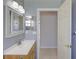 A bathroom featuring a vanity sink, mirror, and adjacent hallway entrance at 7827 Starfire Way, New Port Richey, FL 34654