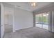 Large bedroom with gray carpet and sliding glass doors that lead to the pool at 7827 Starfire Way, New Port Richey, FL 34654