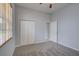 This bedroom features neutral walls, carpet, window with blinds and closet at 7827 Starfire Way, New Port Richey, FL 34654