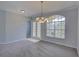 This spacious dining room features a large window and stylish chandelier at 7827 Starfire Way, New Port Richey, FL 34654