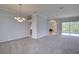 Inviting living room with gray walls, carpet, and views to the patio and pool at 7827 Starfire Way, New Port Richey, FL 34654