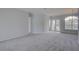 Open living room with modern paint, neutral carpet, and bright glass doors to the exterior at 7827 Starfire Way, New Port Richey, FL 34654
