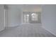 Spacious living room with soft gray carpet, lots of light, and neutral paint at 7827 Starfire Way, New Port Richey, FL 34654