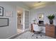 This home office features a desk with chair, art and a glass paneled door at 7827 Starfire Way, New Port Richey, FL 34654