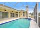 This screened-in pool features ample outdoor space with multiple entrances at 7827 Starfire Way, New Port Richey, FL 34654