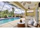 Inviting screened-in pool area with a kitchenette, ceiling fans and comfortable seating at 7827 Starfire Way, New Port Richey, FL 34654