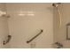 A bathroom featuring safety grab bars and adjustable shower head at 840 Virginia St # 202, Dunedin, FL 34698