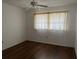 Cozy bedroom with dark wood floors, ceiling fan, and a large window at 840 Virginia St # 202, Dunedin, FL 34698