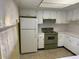 Cozy kitchen with white cabinets, a classic green stove, and bright natural light at 840 Virginia St # 202, Dunedin, FL 34698