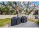 Outdoor deck area with two Weber grills, surrounded by mature trees at 840 Virginia St # 202, Dunedin, FL 34698