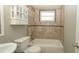 Bright bathroom features a white vanity, built-in cabinet, and tiled shower-tub combination at 8522 Inwood Dr, Hudson, FL 34667