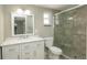 Bathroom featuring a white vanity, toilet, and a tiled shower with glass doors at 8522 Inwood Dr, Hudson, FL 34667