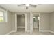 Bedroom with wood-look tile flooring, ceiling fan, window, and doorways to closet and bathroom at 8522 Inwood Dr, Hudson, FL 34667