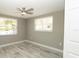 Bedroom with wood-look tile flooring, ceiling fan, and windows at 8522 Inwood Dr, Hudson, FL 34667