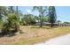 Well-maintained front yard with trees and a glimpse of the home's facade at 8522 Inwood Dr, Hudson, FL 34667