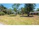Grassy front yard with mature trees provides a serene and welcoming entry at 8522 Inwood Dr, Hudson, FL 34667