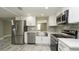 Renovated kitchen showcasing stainless steel appliances, bright white cabinets, and quartz countertops at 8522 Inwood Dr, Hudson, FL 34667
