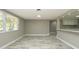 Bright living room featuring modern flooring, a large window, and easy access to the adjacent kitchen area at 8522 Inwood Dr, Hudson, FL 34667