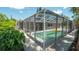 A screened-in pool with tropical foliage and greenery at 8522 Inwood Dr, Hudson, FL 34667