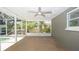 Screened porch overlooks a garden and pool with a fan and lots of light at 8522 Inwood Dr, Hudson, FL 34667