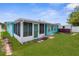 Exterior view of the turquoise home with an enclosed porch and backyard shed at 9015 Mark Twain Ln, Port Richey, FL 34668