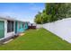 Exterior shot with fence, green grass, shed and the back of the house at 9015 Mark Twain Ln, Port Richey, FL 34668